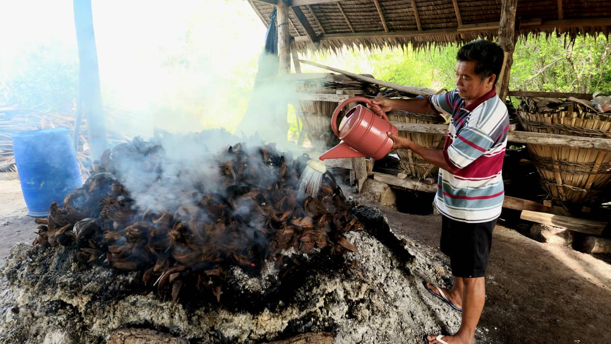Coconut husks are burned and intermittently doused with seawater.